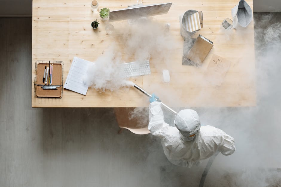 office worker cleaning desk with disinfectant